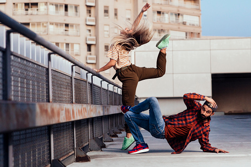 B-boy and girl doing freestyle dancing on rooftop