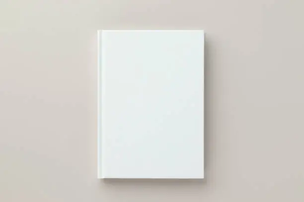 Photo of White book blank cover mockup on a beige background, flat lay, mockup