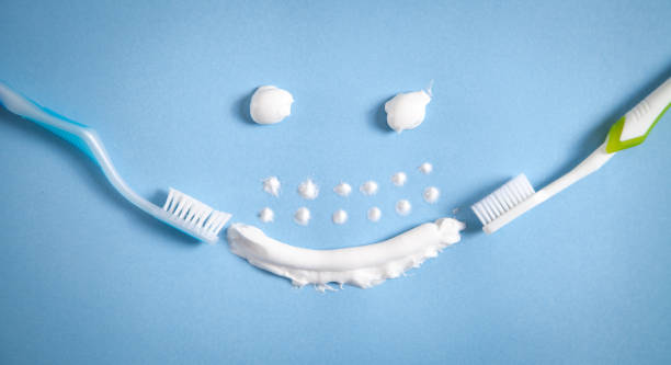 spazzolino da denti e dentifricio su sfondo blu. faccia sorridente - 11088 foto e immagini stock