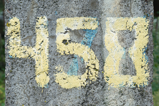Four hundred and fifty eight number painted with yellow paint on Ñoncrete wall. Hand drawing four, five, eight symbols