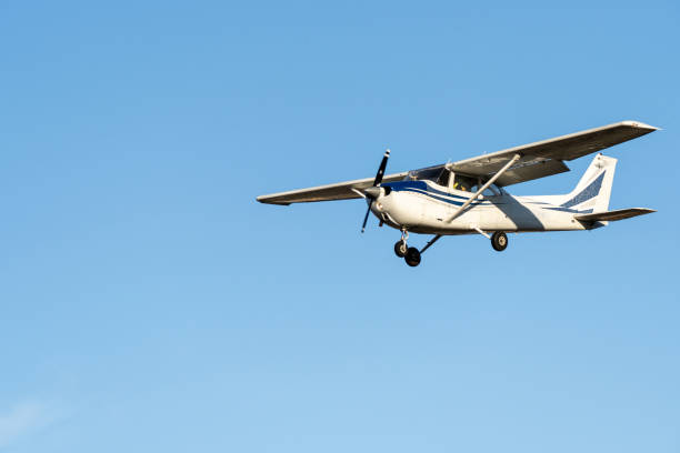 kleines flugzeug, das mit sonnenuntergangslicht bei klarem himmel fliegt, bevor es auf dem flughafen sabadell landet. - propellerflugzeug stock-fotos und bilder