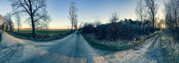 istock Panoramic image of a crossroads in a forest next to a moorland. 1387107072