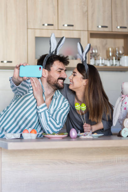 istock Beautiful young couple looking at each other taking a photo for Easter 1387107191