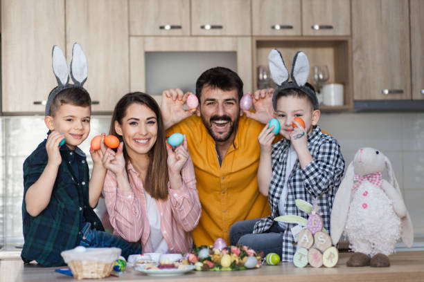 istock Happy family posing with colorful Easter eggs in their hands 1387108529