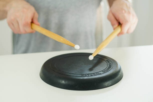istock Close up of young drummer holding drum sticks and practicing on a black drum pad. 1387110577
