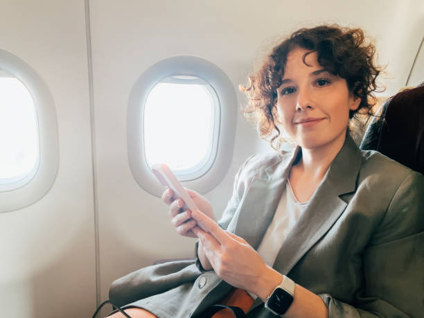 istock A Beautiful Caucasian Female Holding Her Mobile Phone While Looking At Camera 1387110811