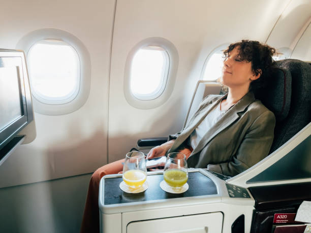 istock A Young Businesswoman Taking A Nap While Being On A Plane 1387110818