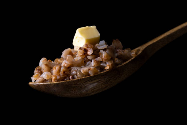 istock buckwheat in a wooden spoon on black background 1387111612