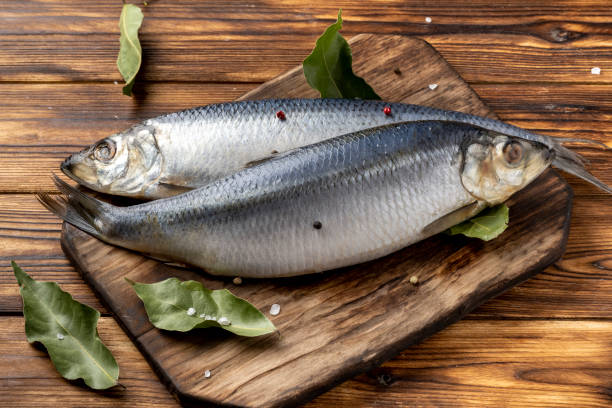 istock two salted herring on a wooden table with spices 1387111884