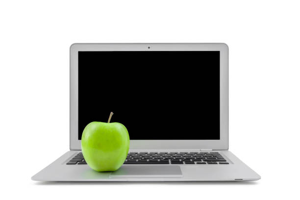 Laptop and green apple isolated on white background.