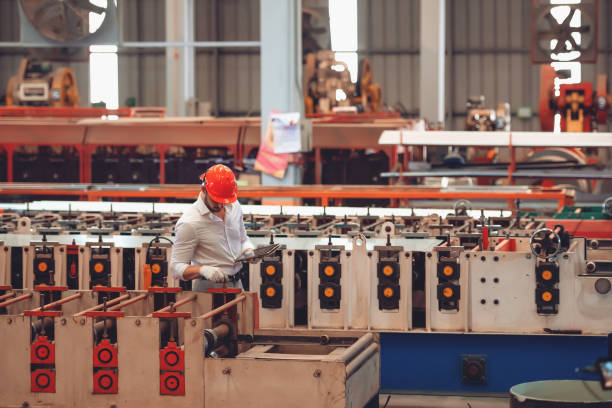 istock Factory worker checking electrical machine process at industrial worksite , wearing hard hat for safety 1387115799