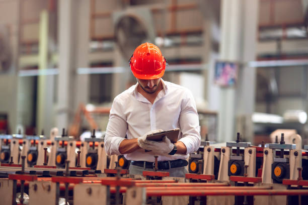 istock Factory worker checking electrical machine process at industrial worksite , wearing hard hat for safety 1387115808