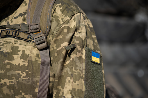 Bandera ucraniana en un uniforme militar, guerra. Soldado de las Fuerzas Armadas de Ucrania. Defensa territorial photo