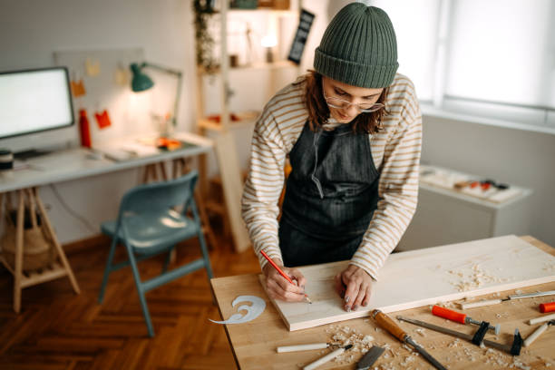 istock Female artist drawing on wood over workbench in art studio 1387121591