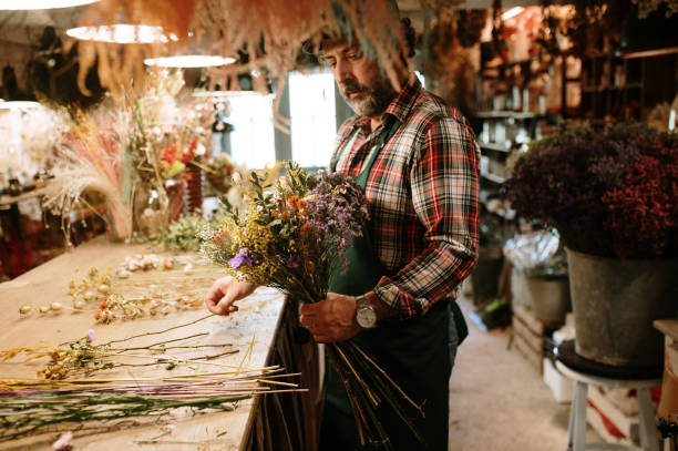 istock Florist arranging a dried flowers bouquet 1387122552