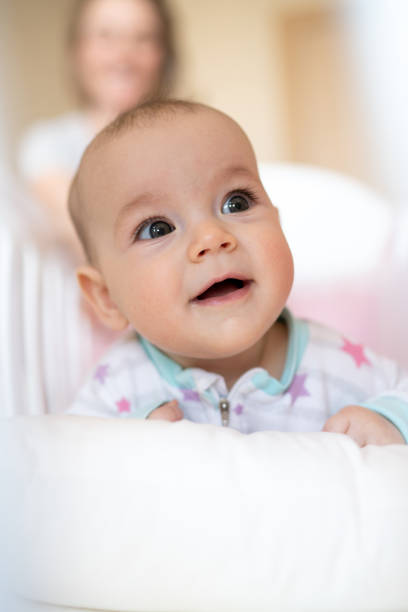 istock Cute baby girl lying in crib 1387123377