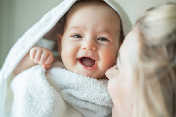 mujer cargando a su bebé en casa - baby cute laughing human face fotografías e imágenes de stock