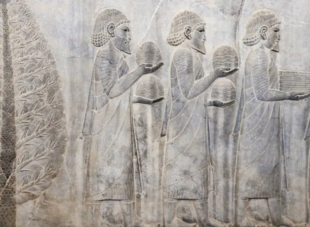 Photo of Ancient wall with bas-relief with assyrian foreign ambassadors with gifts and donations, Persepolis, Iran