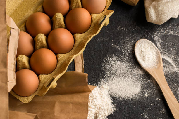 istock Fresh natural chicken eggs in eco package, flour on a dark kitchen table, linen towel. Traditional ingredients for baking. Flat lay. Kinfolk style. 1387125556