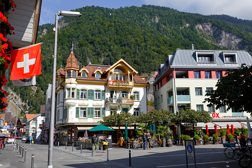 Interlaken, Switzerland - September 07, 2015: Alpine building with picturesque turret located in the heart of the city, on the ground floor housed famous Cafe de Paris, popular tourist destination. This is one of the countless wonderful places in Switzerland, which is a tourist attraction often visited by many tourists from all over the world.