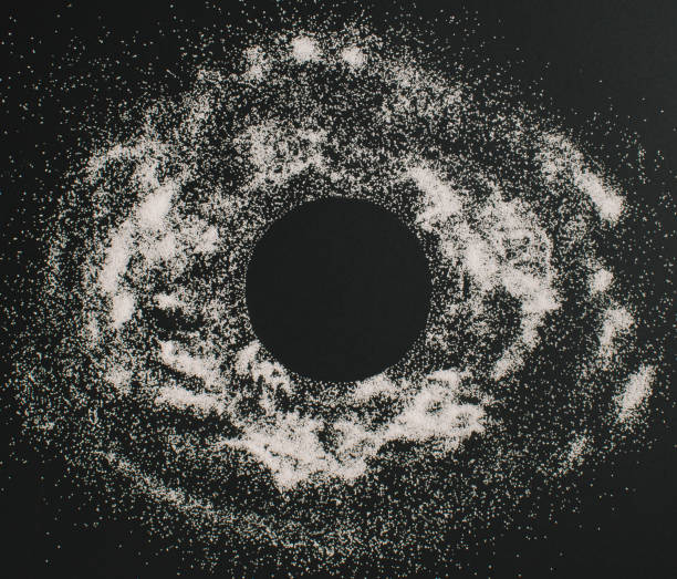 istock White sand against a black background making black hole 1387128064