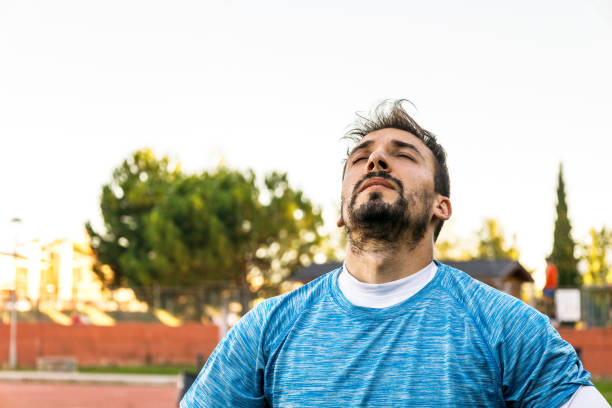 istock man catching air and breathing deeply after doing his workout outdoors, closeup view 1387130235