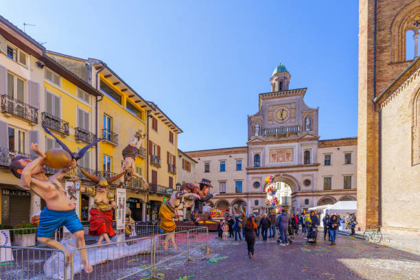 Crema, Italy - February 27, 2022: Carnival market scene in the Cathedral (Duomo) square, with parade figure, locals, and visitors, in Crema, Lombardy, Northern Italy (parade deleted due to COVID)