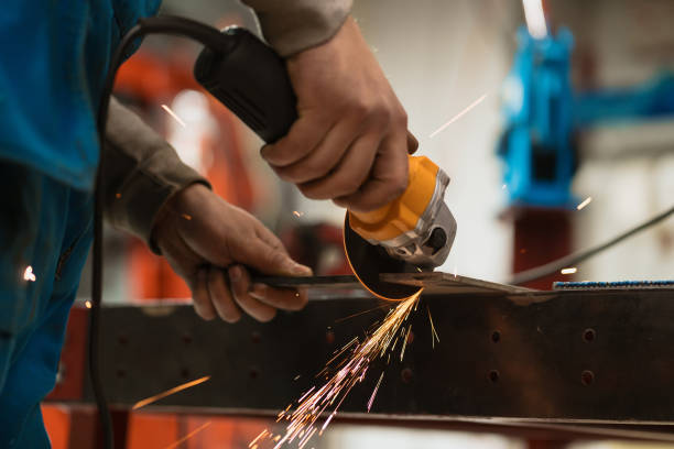 istock Worker working with a circular grinder on a metal with sparks 1387132725