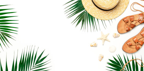 istock Woman's beach accessories flat lay. Straw hat, leather sandals, tropical palm leaves, seashells, starfish on white background. Top view copy space. Summer backdrop 1387134624