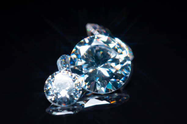 Cut and polished diamonds selective focus on black glossy table. Luxury gem stones collection. Brilliant sparkling gemstone diamonds round shape cut in different sizes. Display and inspection. los diamantes cortados y pulidos se centran selectivamente en la mesa negra brillante. colección de piedras preciosas de lujo. brillantes diamantes de piedra preciosa brillante de forma redonda tallados en diferentes tamaños. exhibición e inspección.