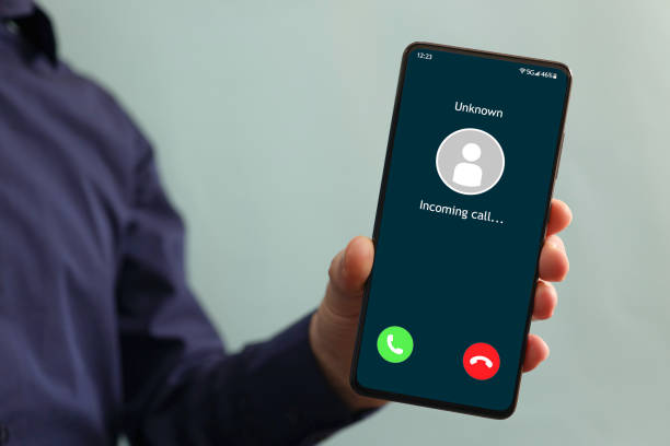 istock Male hand holding a smartphone with unknown caller displayed on screen. 1387136515