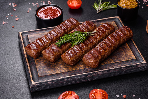 Shish kebab with vegetables on black concrete background