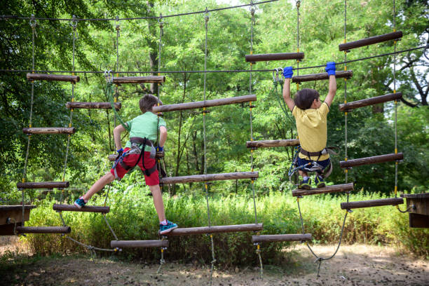 istock Two strong excited young friends playing outdoors in rope park. 1387136847