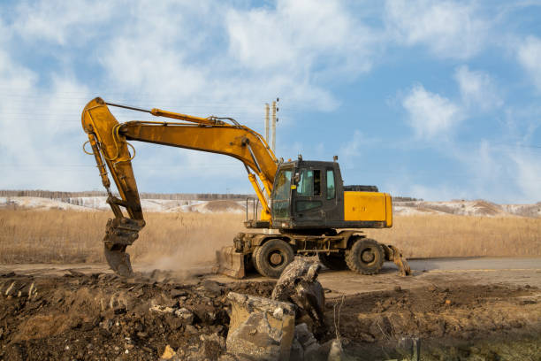 istock A working excavator with attachments on the construction of a road junction. 1387136886