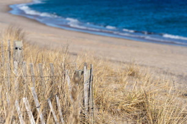 Rhode Island Beach Dune and Fence A quintessential southern Rhode Island beach features dune grass and fencing, the beach, and the Atlantic Ocean. westerly rhode island stock pictures, royalty-free photos & images