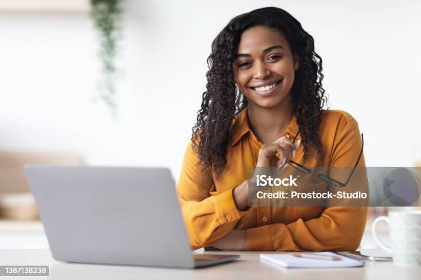 Pretty African American Woman Freelancer Using Laptop At Home Stock Photo - Download Image Now