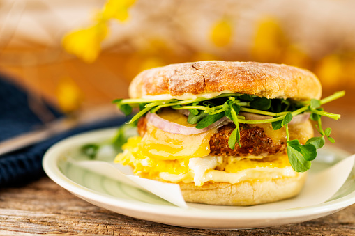 A gourmet jalapeno and fennel sausage patty with egg breakfast sandwich on a English muffin.