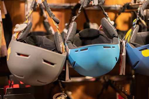 Snowboard and ski helmets hanging at store