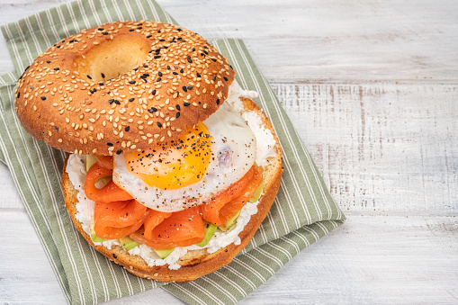 Bagel sandwich with smoked salmon, cream cheese, avocado and egg.