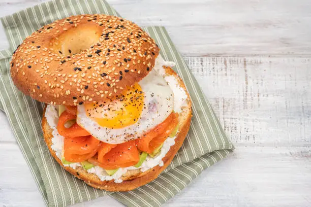 Photo of Bagel sandwich with salmon, cream cheese, avocado and egg.