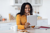 istock Happy black woman using digital tablet and having coffee break 1387141965