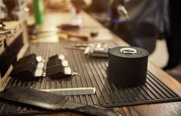 istock Barber shops tools. Accessories for cutting on the table in a barbershop. Comb, brush, scissors, clipper and nozzles. 1387146174