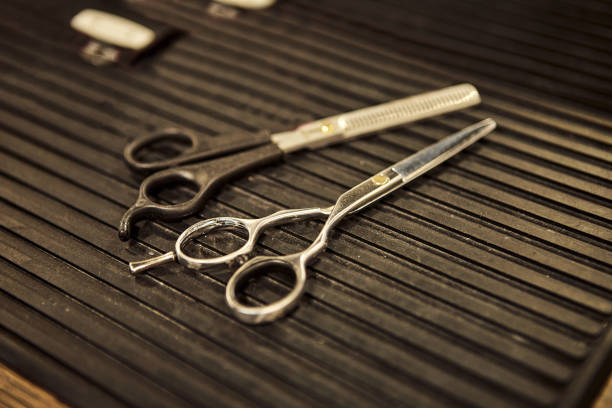 istock Barber shops tools. Scissors for cutting lying on the table in a barbershop 1387146199