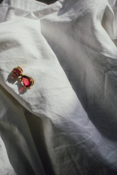 istock single red jewel gold earring on white sheets 1387147453