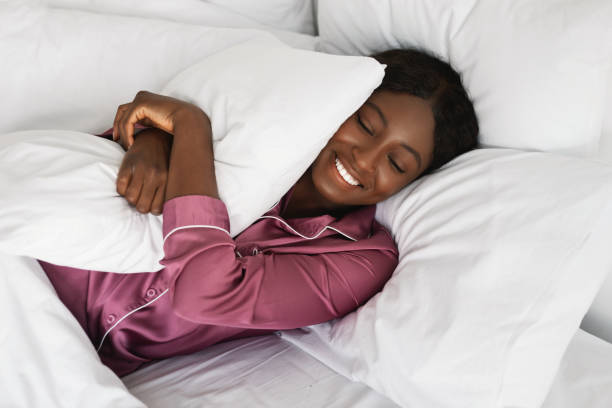 istock Black Lady Embracing Pillow Lying In Bed Resting In Bedroom 1387147523
