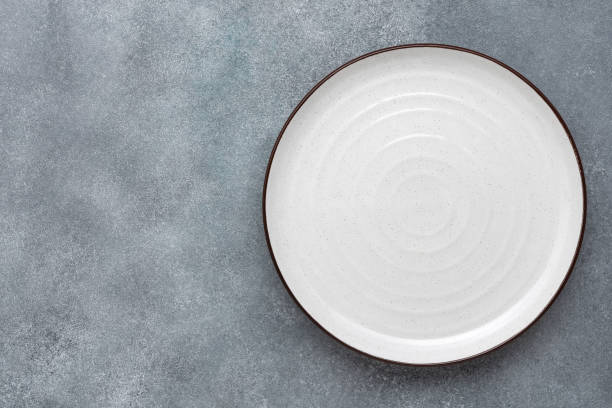 istock Empty white plate on gray concrete background. Top view, flat lay. 1387148190