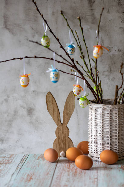 istock Branches with Easter eggs in a vase of willow branches and Easter bunny on a light background 1387148593