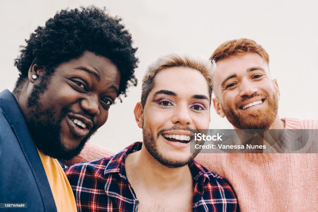 Diverse friends having fun together doing selfie outdoor - Focus on gay male face wearing makeup Only Men Stock Photo