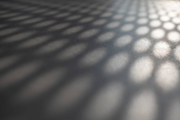 istock Beams of sunlight shining through perforated sheet metal 1387149999