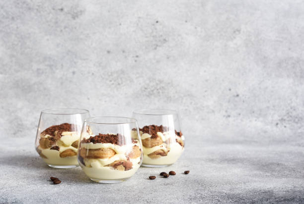 Italian dessert tiramisu in a glass."nClassic tiramisu with coffee on a concrete background. stock photo